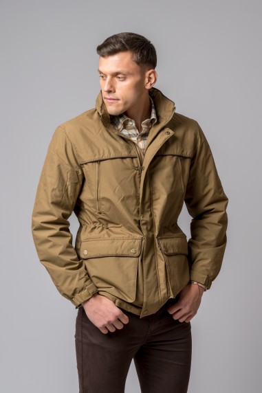 Homem com casaco bege de tecido sintético e calças castanhas em fundo cinzento