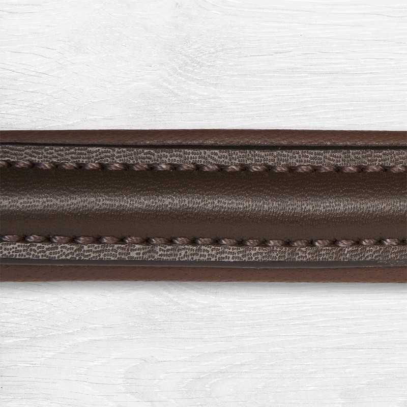 Cinta de couro castanho com costura sobre superfície de madeira branca