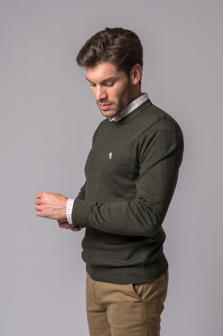 HOMEM A VESTIR CAMISOLA DE MALHA VERDE ESCURA E CALÇAS BEGE