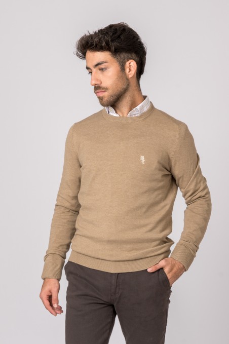 Homem vestido com sweater bege de malha e calças cinzentas