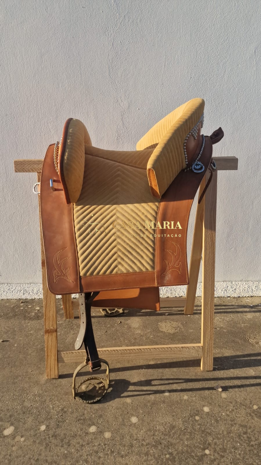 Sela de equitação bege e castanha com textura acolchoada e detalhes em couro