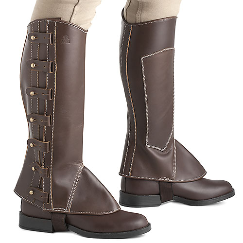 Polainas marrons em couro com fechos e costuras, usadas com calças bege