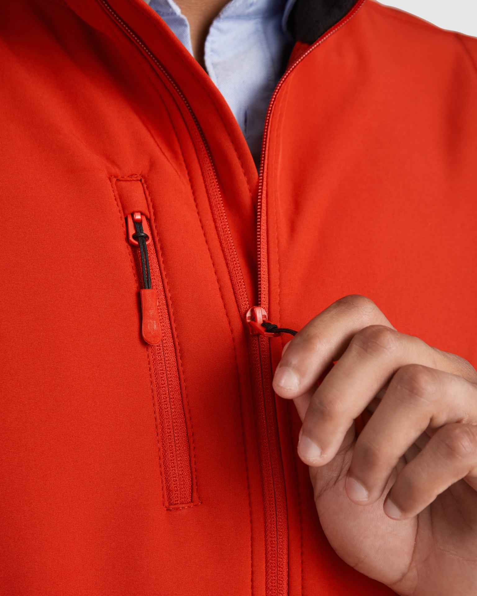 Casaco vermelho com fechos de correr em detalhe