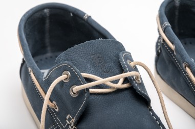 Sapatos de couro azul escuro com cadarços bege e costura branca