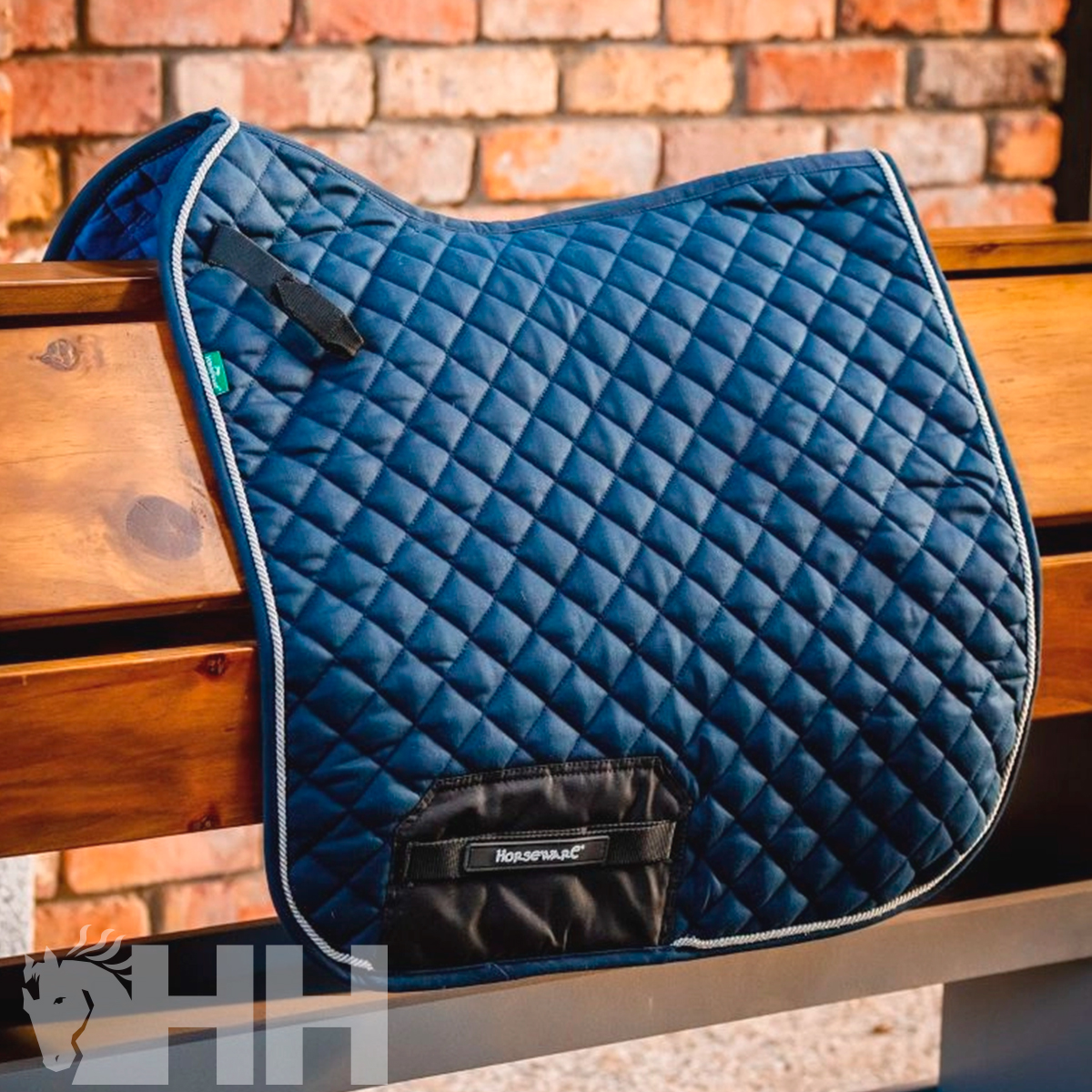 Manta de sela azul escura em padrão de losangos com etiqueta HUSHPAC