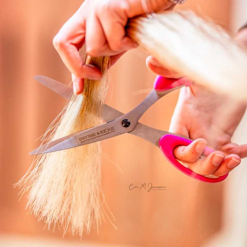 Tesouras de cabelo com cabos rosa a cortar cabelo louro claro