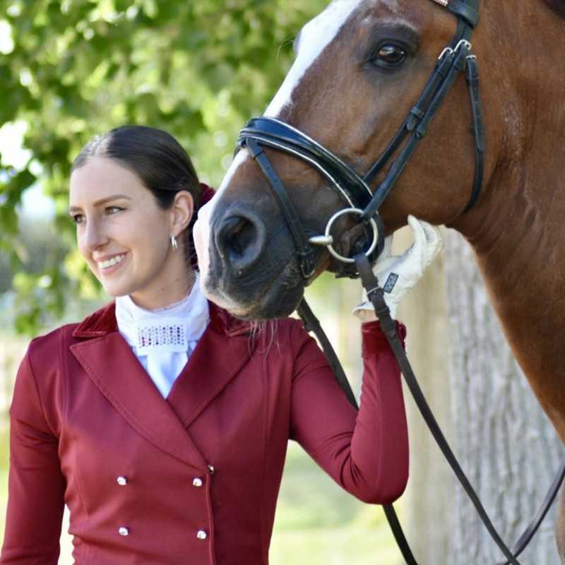 Mulher com casaco vermelho vinho e cavalo castanho com bridão