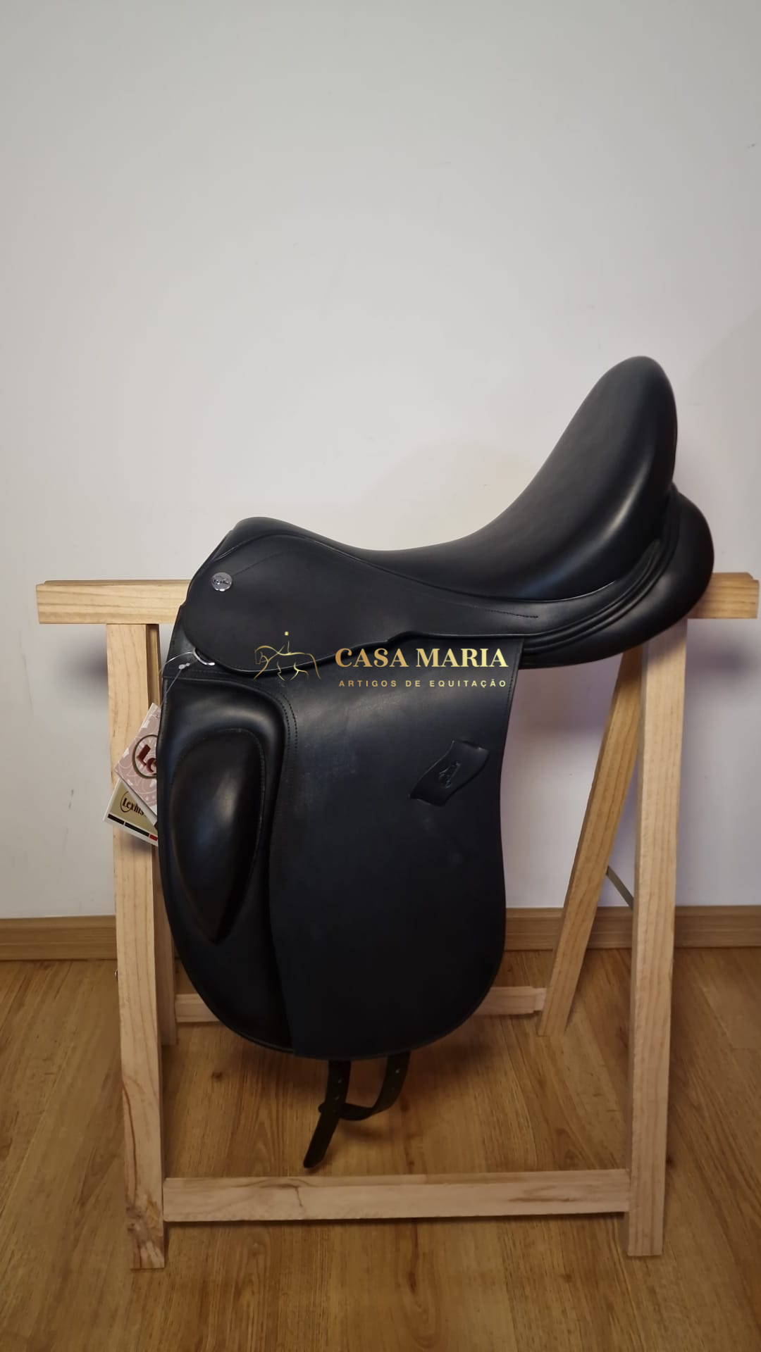 Selim de equitação preto em couro sobre suporte de madeira