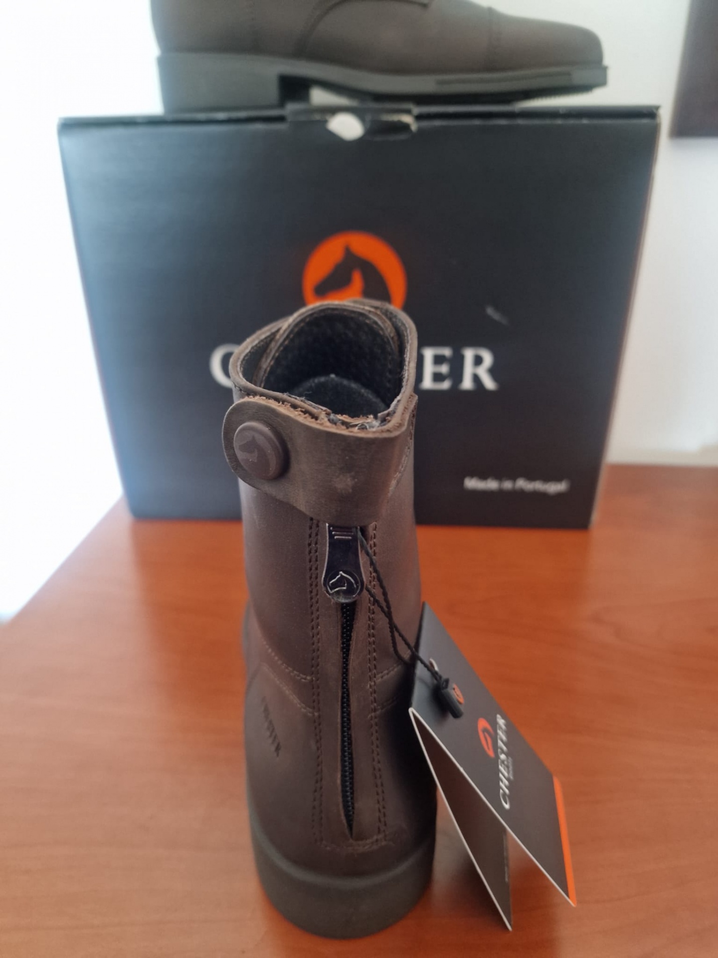 Bota castanha em pele com fecho traseiro e etiqueta pendurada