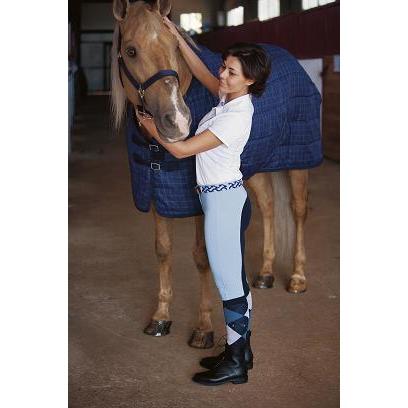 Mulher a acariciar cavalo com manta azul em estábulo