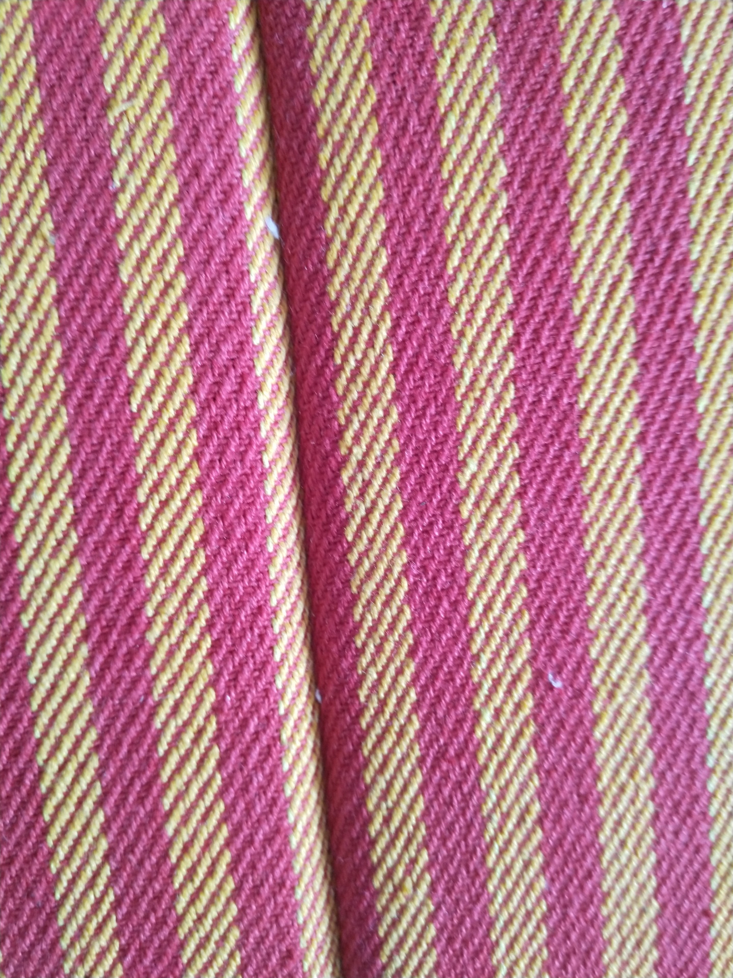 Tecido riscado vermelho e amarelo com textura visível