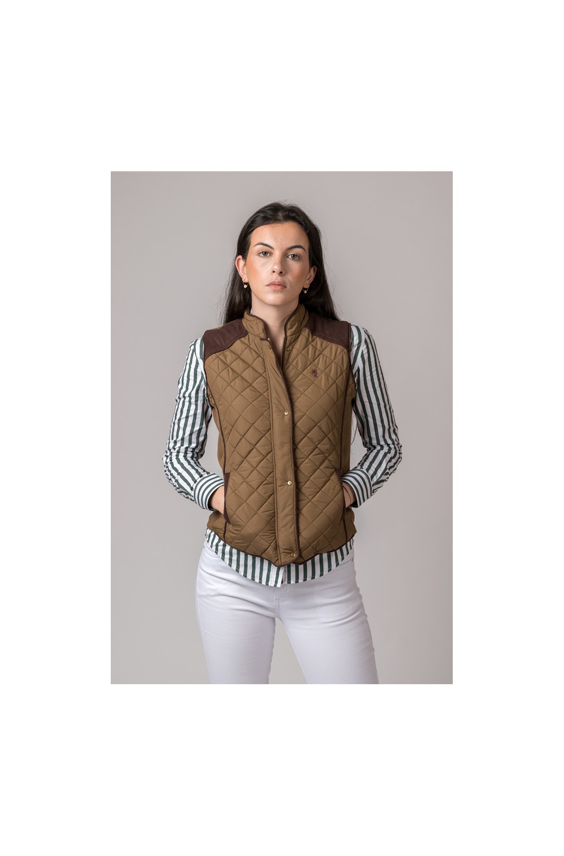 Colete acolchoado castanho com padrão de losangos e botões dourados, camisa com riscas pretas e calças brancas