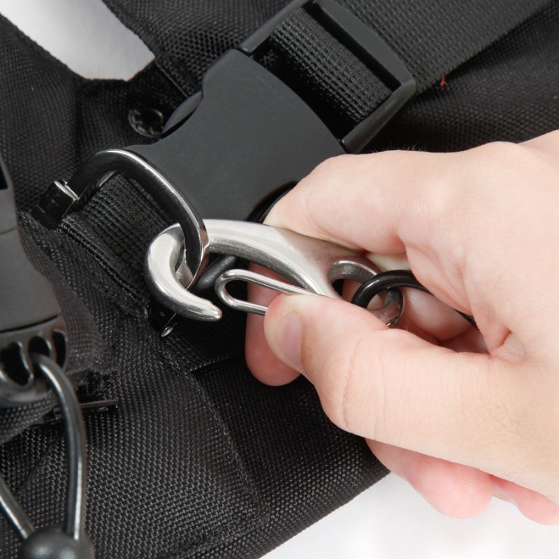 Gancho metálico prateado preso a correia preta com mão segurando