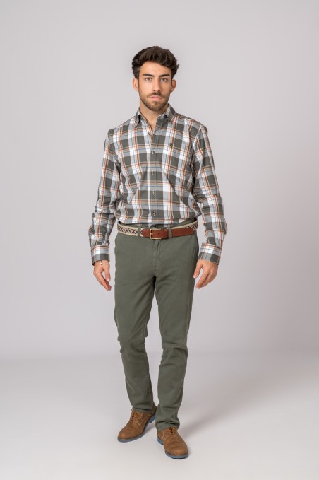 Homem com camisa xadrez e calças verdes em fundo branco
