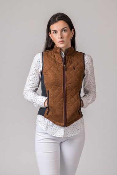 mulher com colete castanho matelassê e camisa branca com pontos
