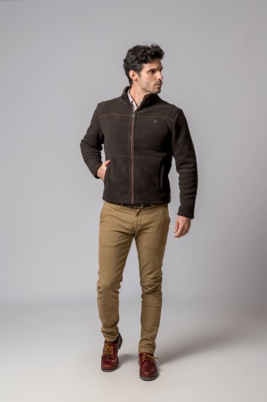 Homem a usar casaco castanho escuro com fecho de correr e calças camel