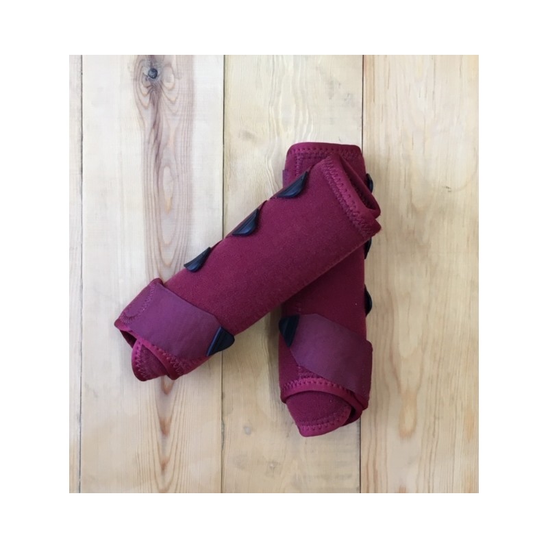 Protetores para pernas vinho com detalhes pretos sobre superfície de madeira clara