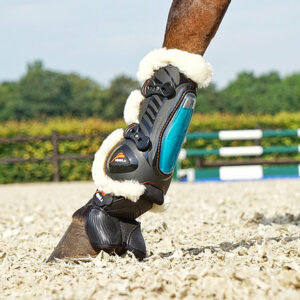 Perneira preta e azul com interior branco felpudo para proteção de cavalo em treino exterior