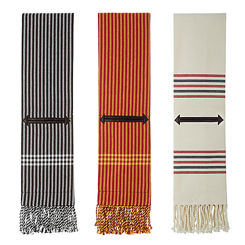 Três toalhas listras em cores preto, vermelho e branco com franjas.