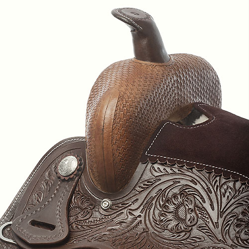 Detalhe de sela de cavalo em couro trabalhado com padrão floral e punho entrelaçado