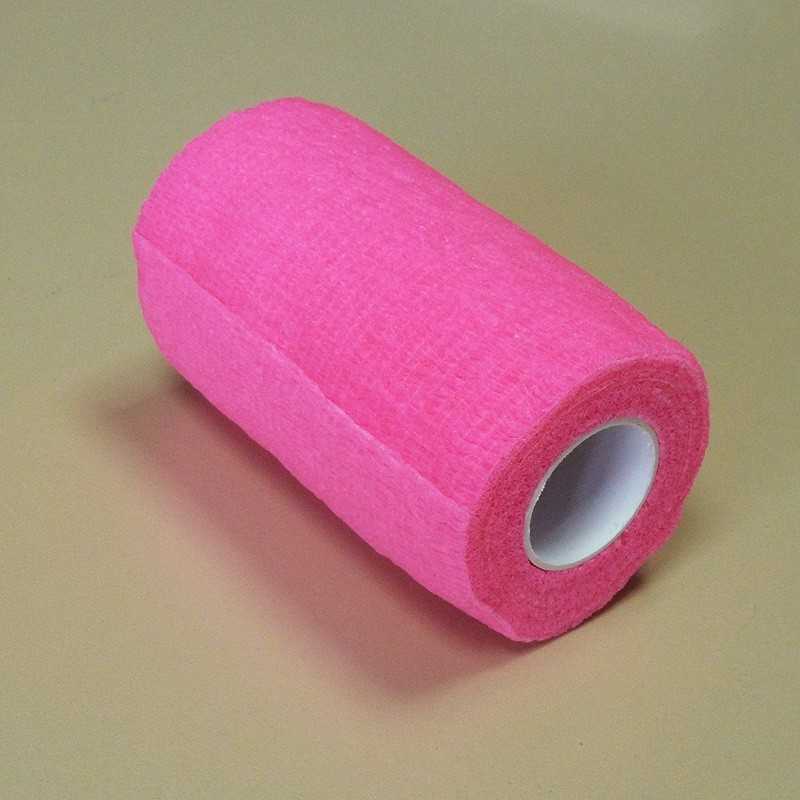 Rolo de fita adesiva rosa sobre superfície beige