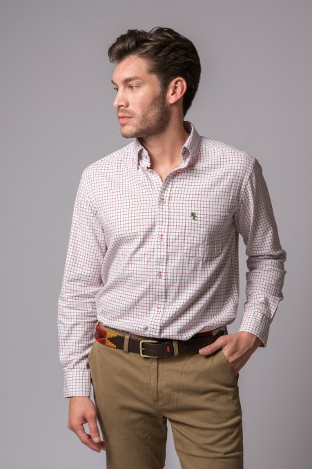 Homem com camisa branca quadriculada vermelha e verde, calças cáqui e cinto colorido