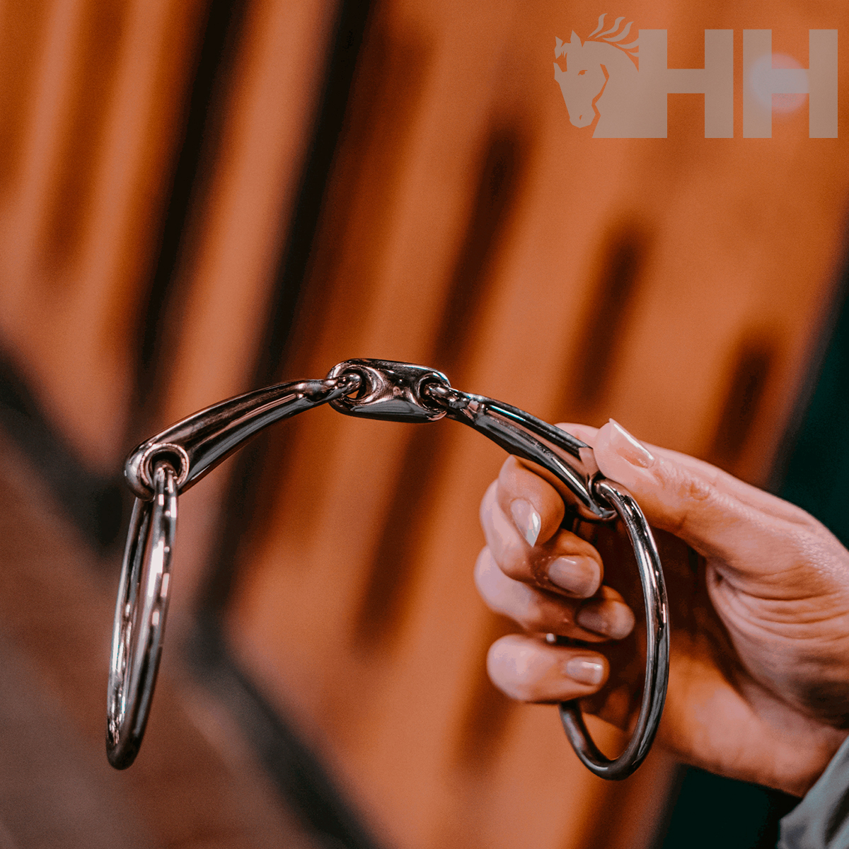 Mão a segurar bocado metálico com anéis grandes