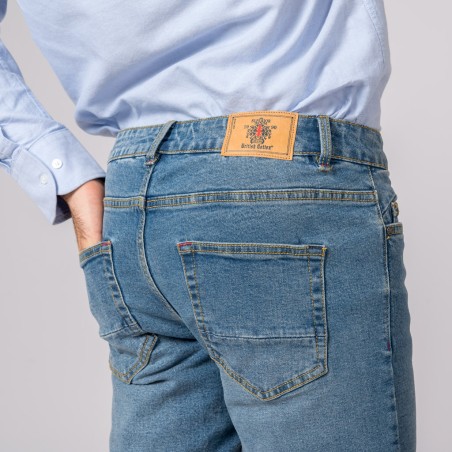 Calças de ganga azuis com etiqueta castanha e camisa azul claro