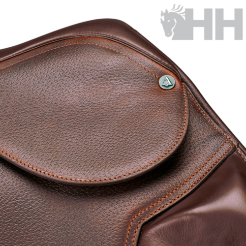 Bolsa de pele castanha com textura granulada e emblema metálico