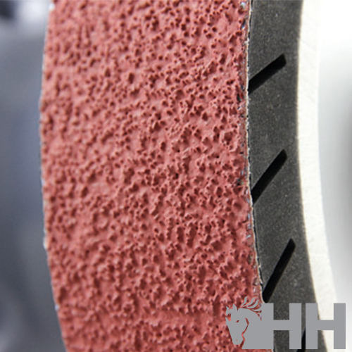 Roda abrasiva vermelha texturada com núcleo branco e bordas pretas recortadas