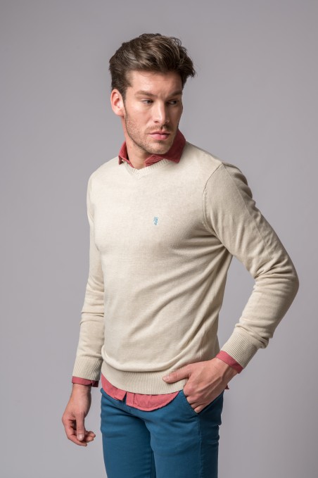 Homem com camisola bege de malha fina e camisa vermelha