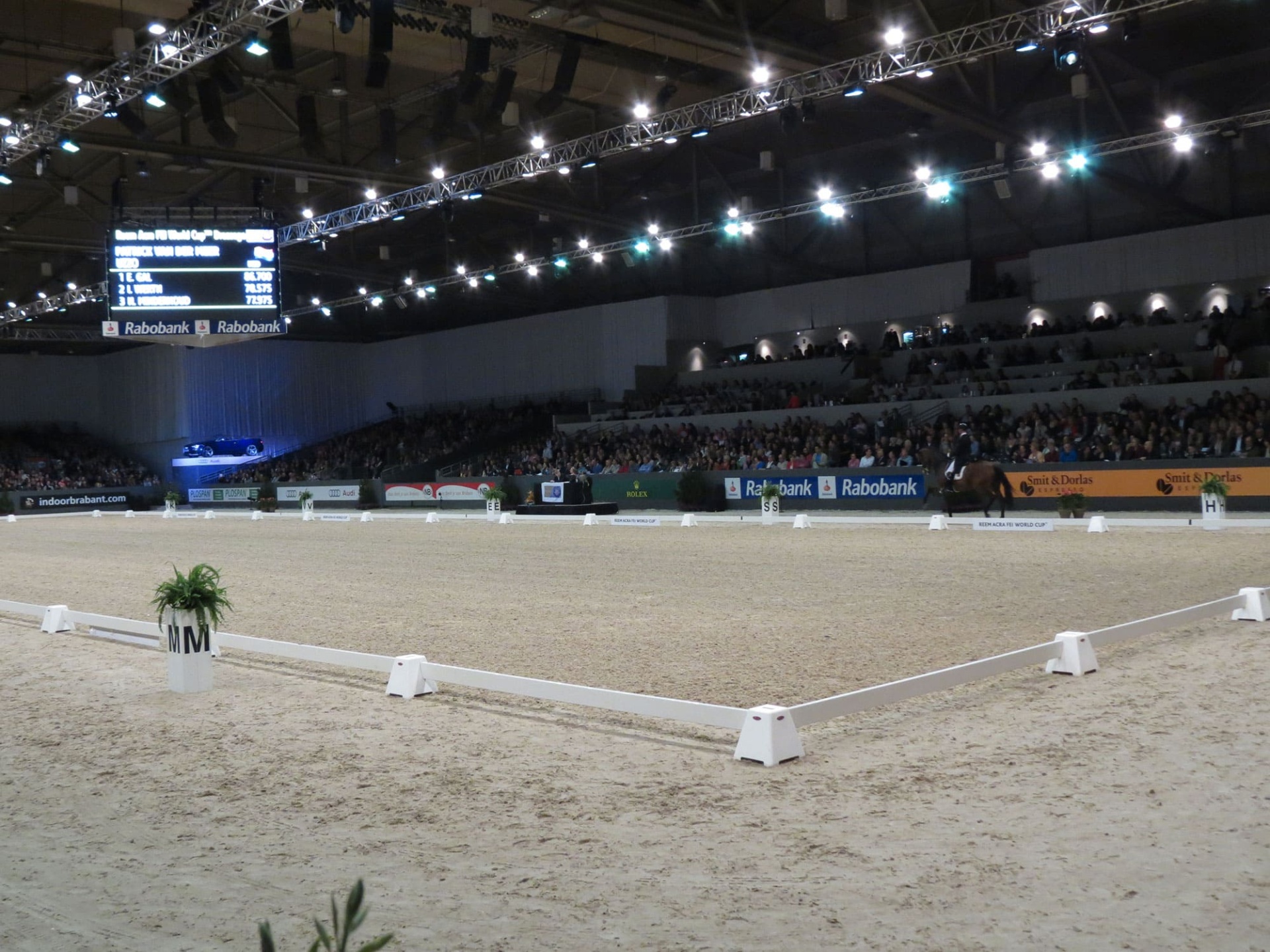 Arena de equitação coberta com piso de areia e publicidade Rabobank