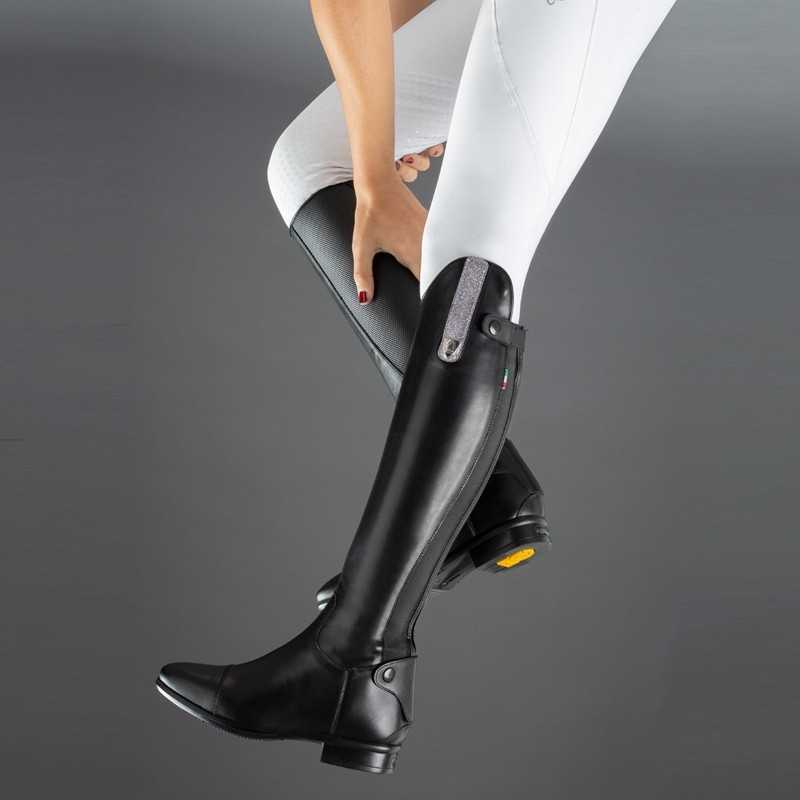 Botas pretas altas até ao joelho usadas com calças brancas