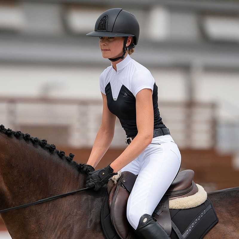 Mulher em equipamento de equitação montada em cavalo castanho com sela preta