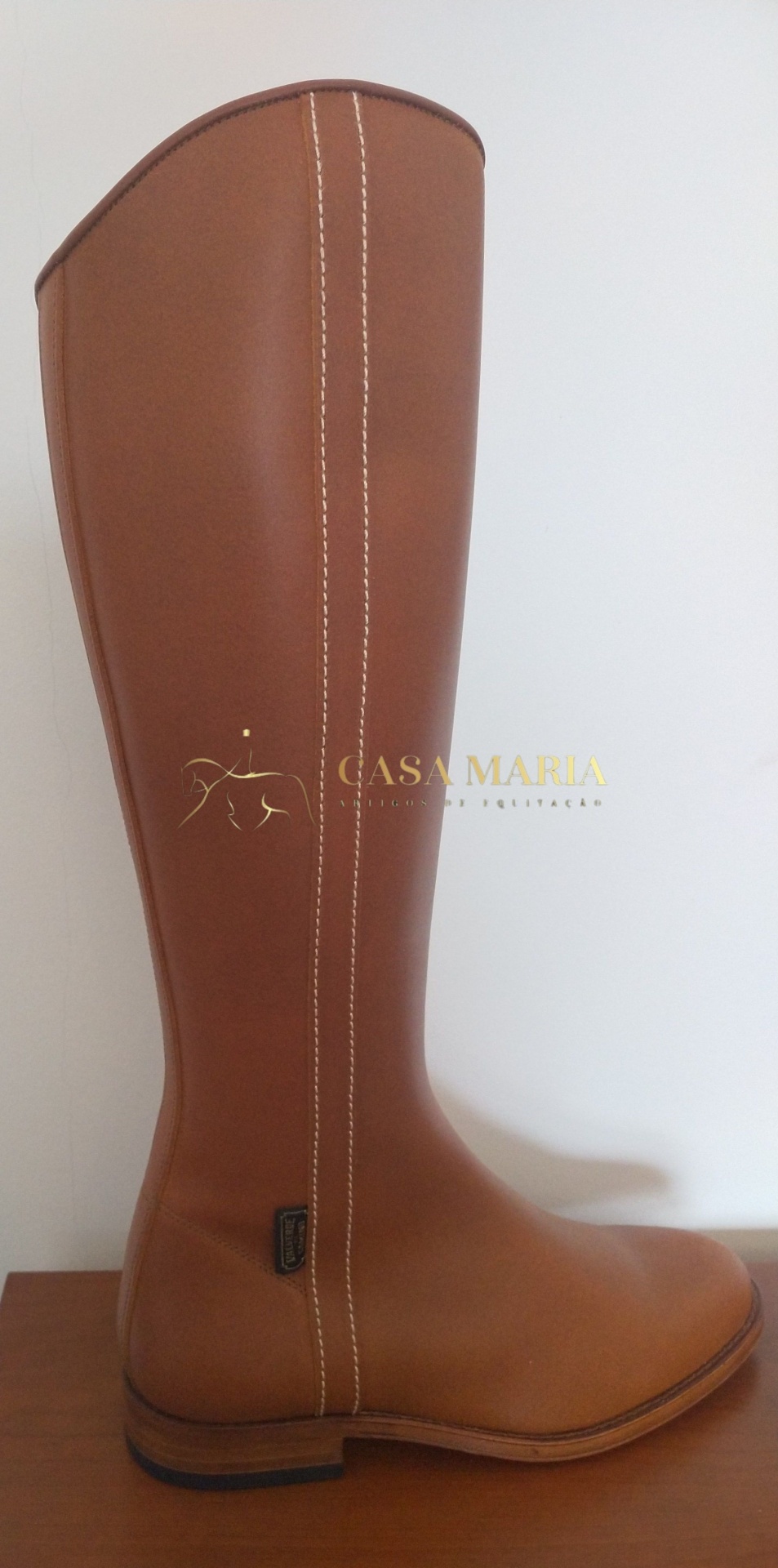 Bota alta de couro castanho com costura branca em fundo branco