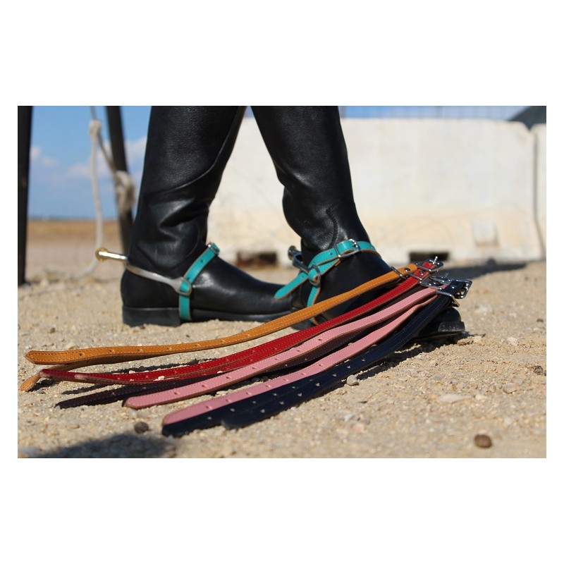 rédeas de couro coloridas com tachinhas metálicas junto a botas com esporas