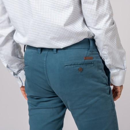 Calças azuis com bolso traseiro de botão e camisa branca quadriculada