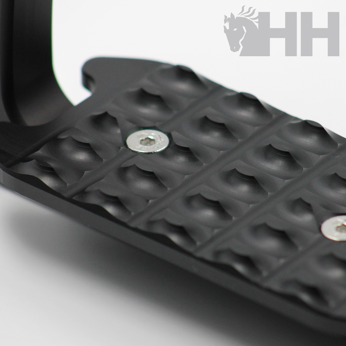 Pedal metálico preto com textura antiderrapante e parafusos visíveis