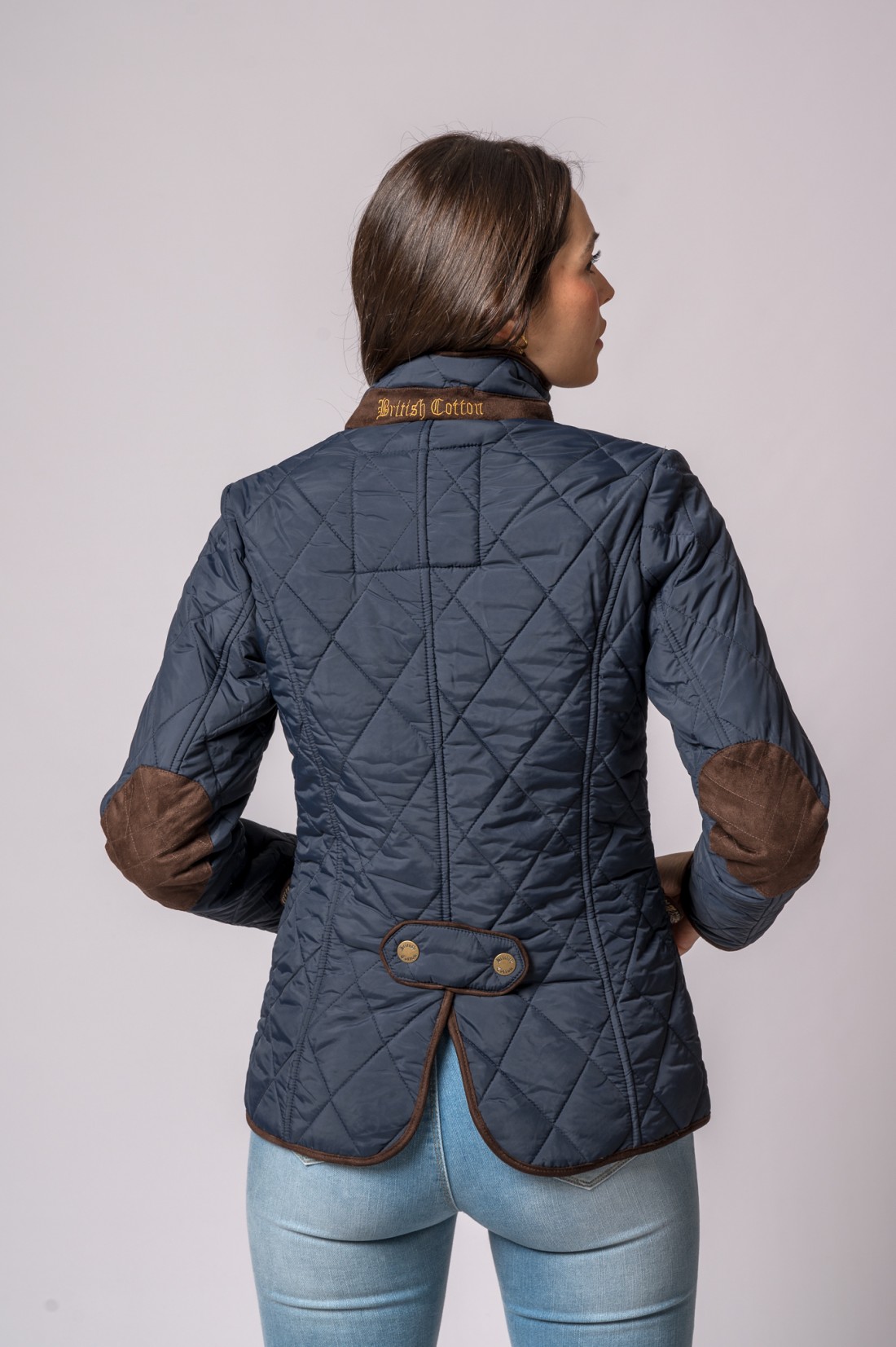 Casaco azul escuro acolchoado com patches marrons nos cotovelos e texto 'Royal Cotton' na gola