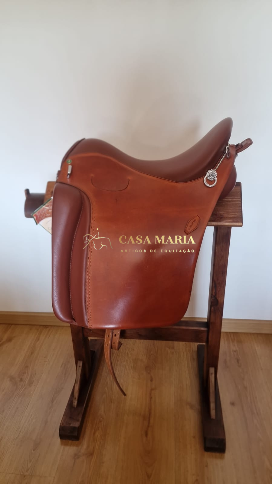 Sela de equitação castanha em couro numa madeira