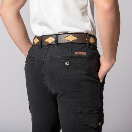 Cinto em pele com padrão geométrico e calças pretas