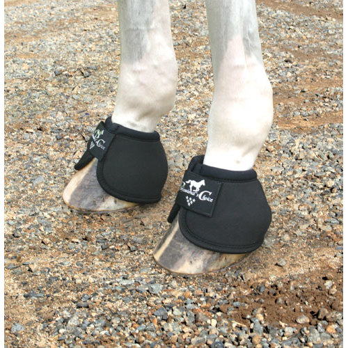 Patas de cavalo com protetores pretos e velcro sobre cascalho