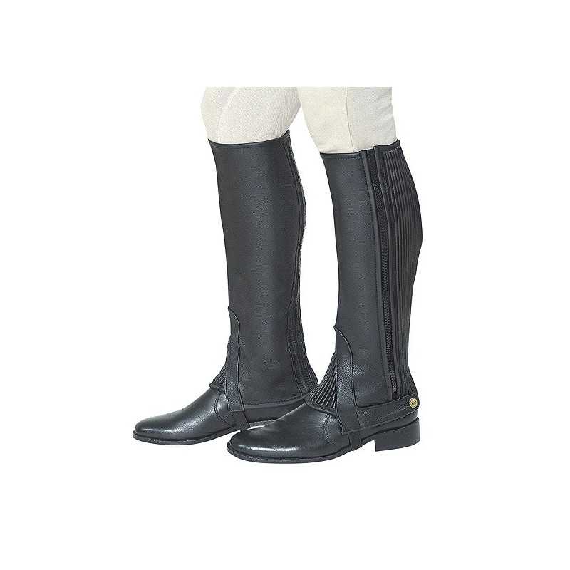 Botas pretas de montaria em couro com elásticos na parte traseira usadas com calças claras.