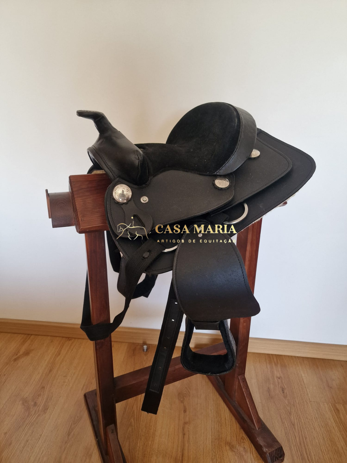 Sela de equitação preta em suporte de madeira