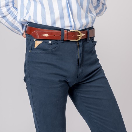 Calças azuis escuras com cinto castanho de couro e camisa branca às riscas azuis