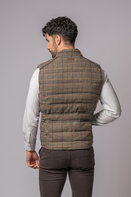 Homem de costas a usar colete acolchoado castanho xadrez e camisa branca xadrez