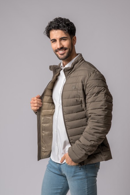 Homem com casaco castanho acolchoado e camisa branca