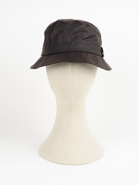 Chapéu bucket castanho escuro num suporte de cabeça bege