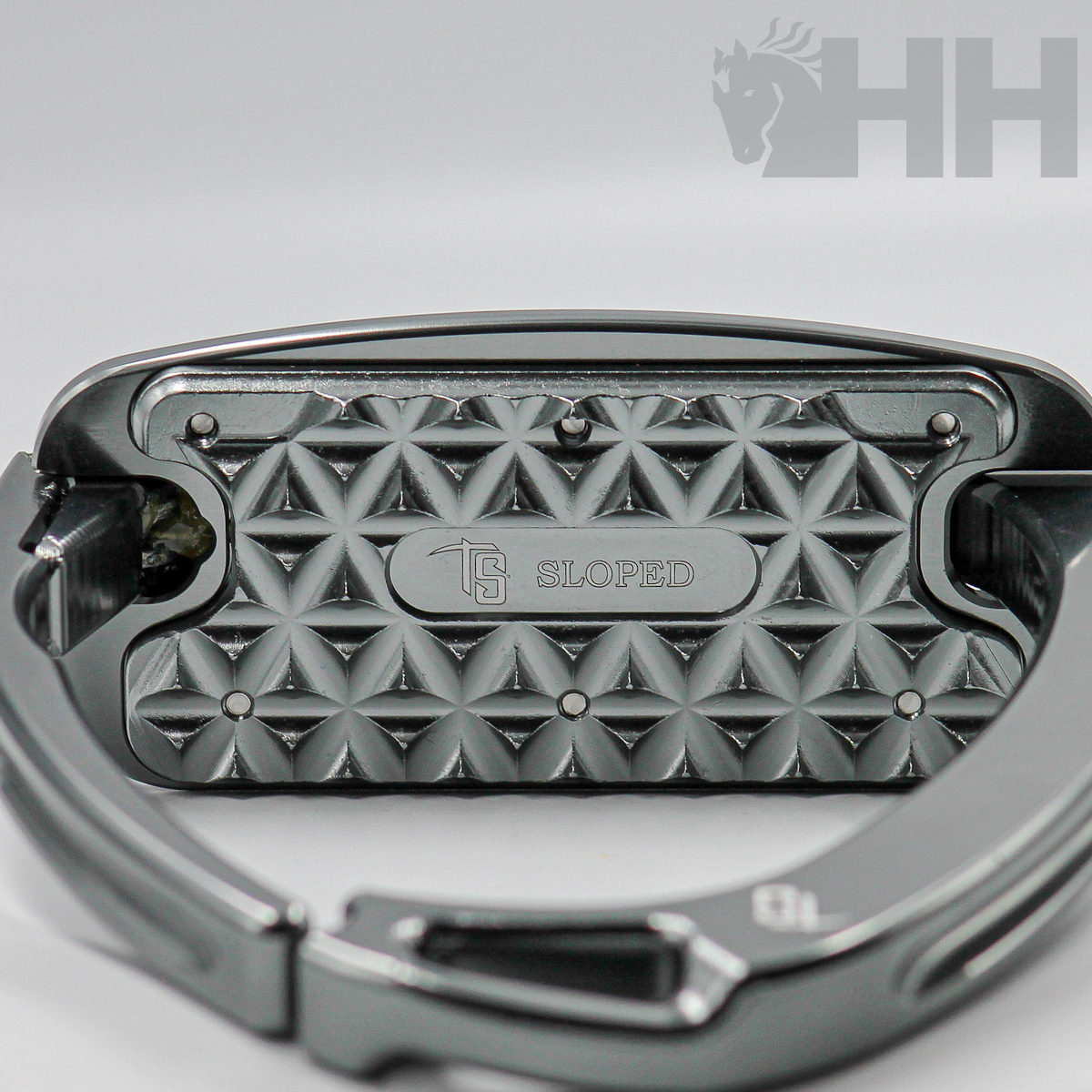 Mosquetão metálico cinza com padrão geométrico e gravação