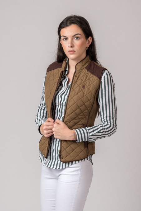 Mulher com colete matelassado castanho e camisa riscada verde e branca